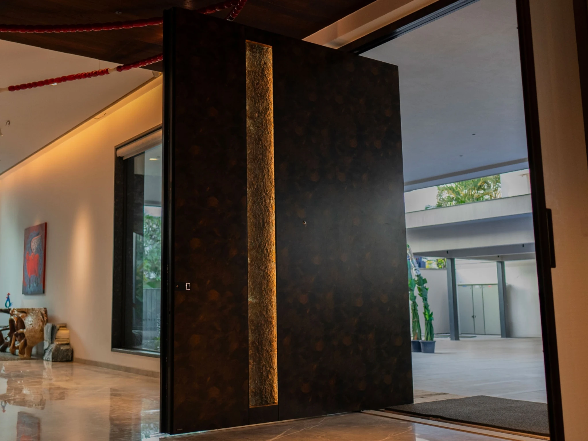 Modern black entry door with concealed hinges on a contemporary home facade